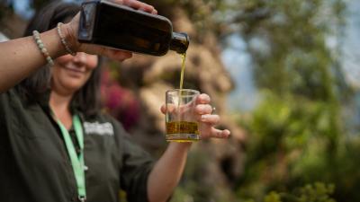 Eden tour guide pouring olive oil into a glass